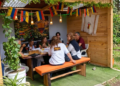 Grupo de docentes disfrutando de un almuerzo en un kiosco privado de madera decorado con banderas de Colombia en el Restaurante 3 Soles.