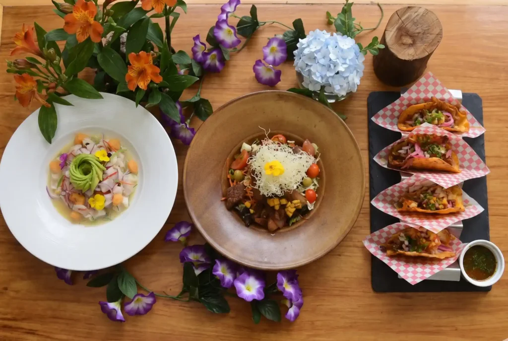 Banquete de cocina fusión en Restaurante 3 Soles: ceviche peruano con aguacate, lomo saltado gourmet y tacos de birria decorados con flores naturales.