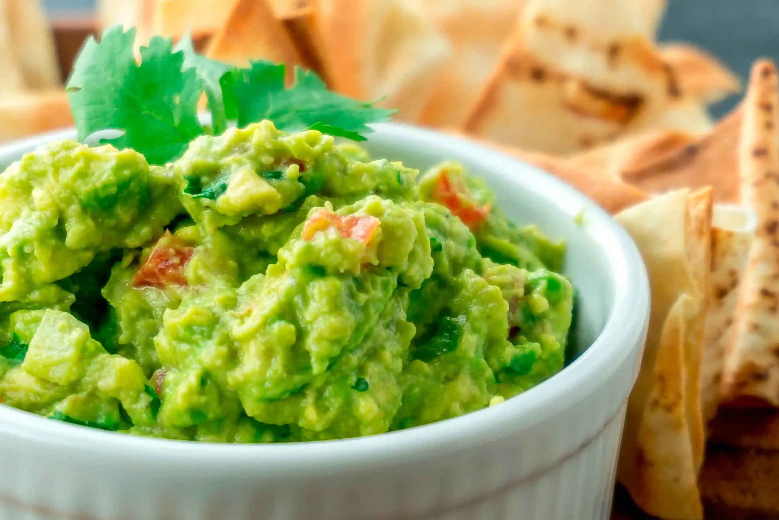 Guacamole fresco con cilantro y tomate servido como entrada mexicana en Restaurante 3 Soles