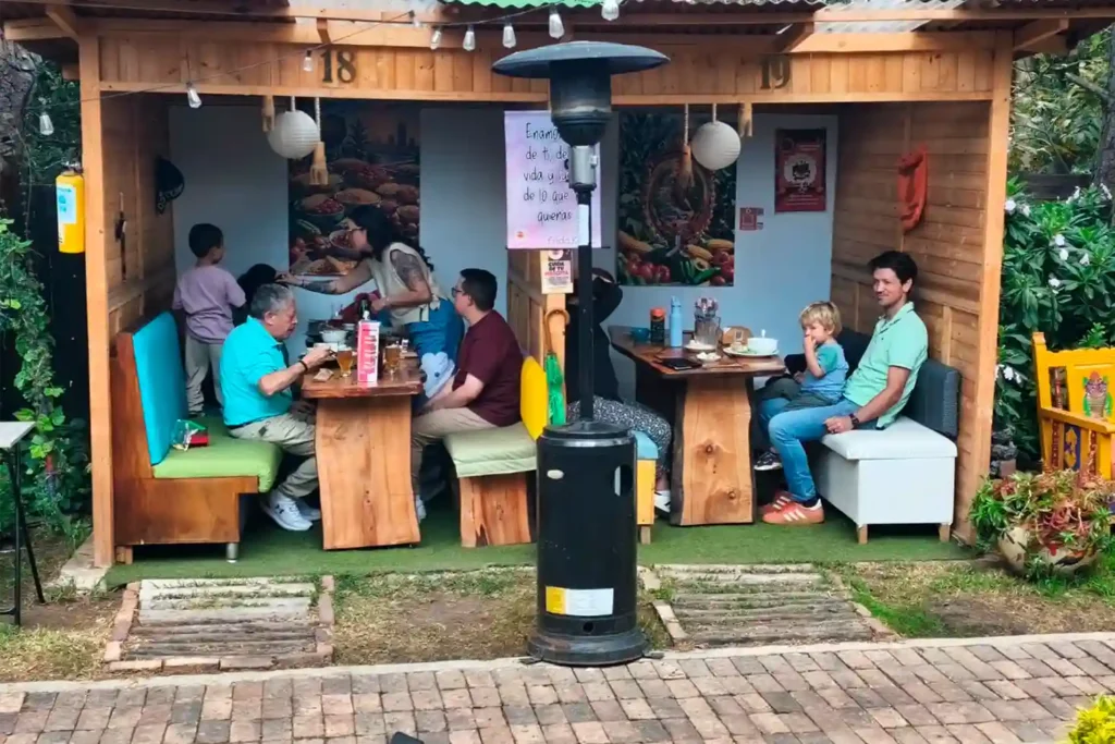 Familias con niños almorzando en kioscos exteriores del Restaurante 3 Soles en Chía.