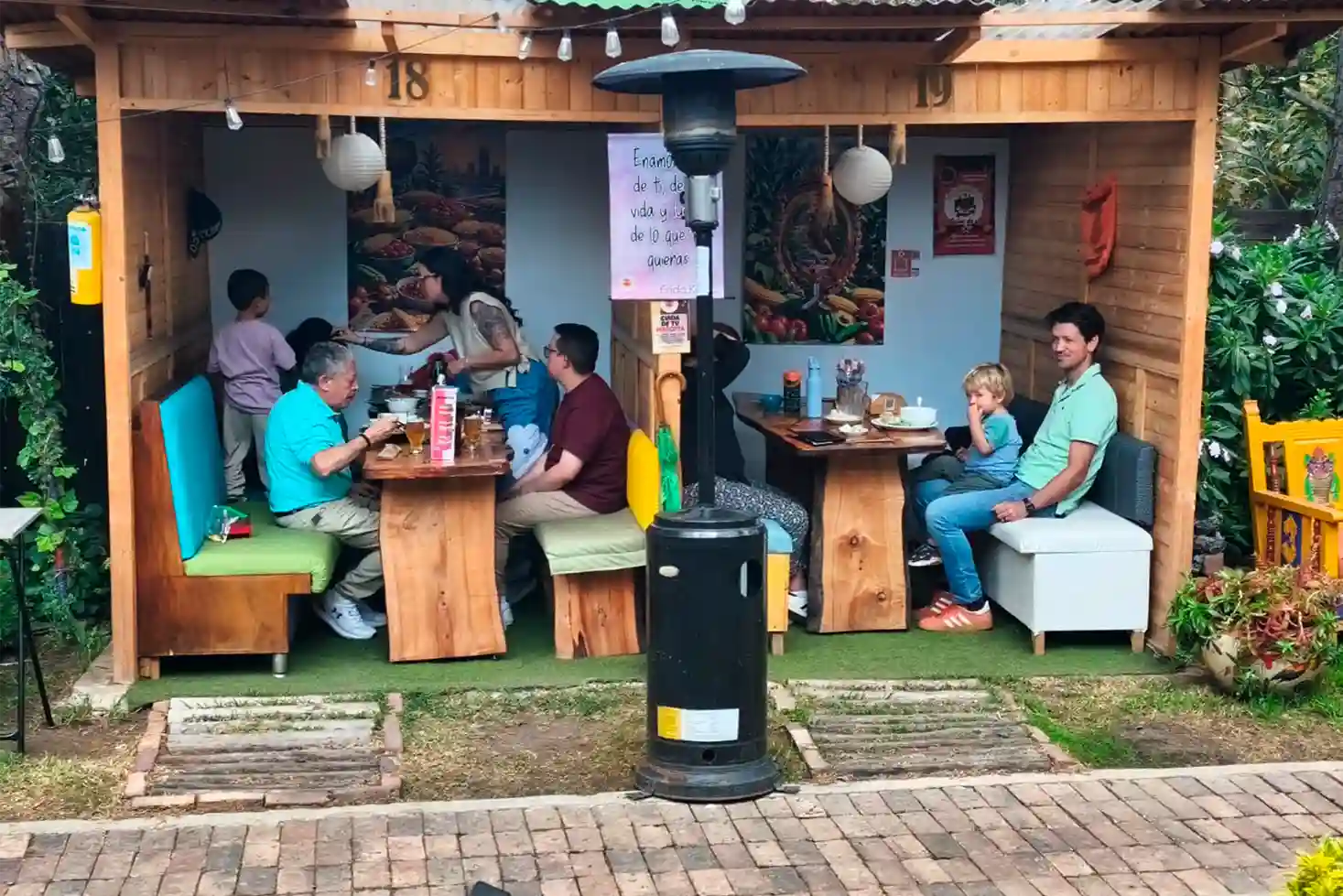 Familias con niños almorzando en kioscos exteriores del Restaurante 3 Soles en Chía.