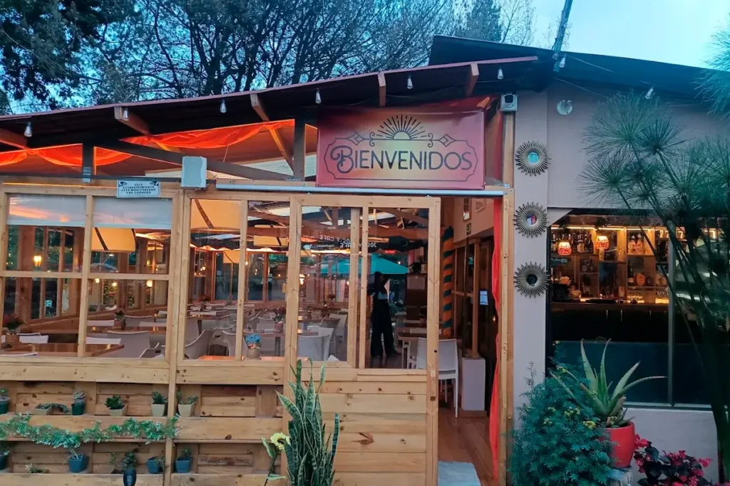 Entrada de 3 Soles con letrero de bienvenidos y salón iluminado al atardecer