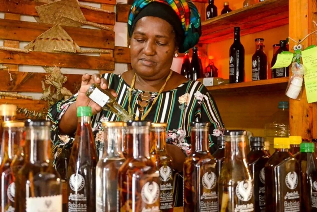 Mujer afrocolombiana sirve viche artesanal entre botellas en evento cultural en Chía
