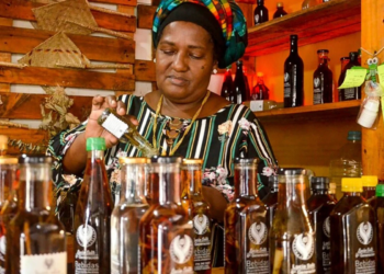 Mujer afrocolombiana sirve viche artesanal entre botellas en evento cultural en Chía