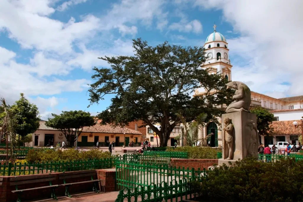 Parque principal de Chía con iglesia colonial y escultura en primer plano