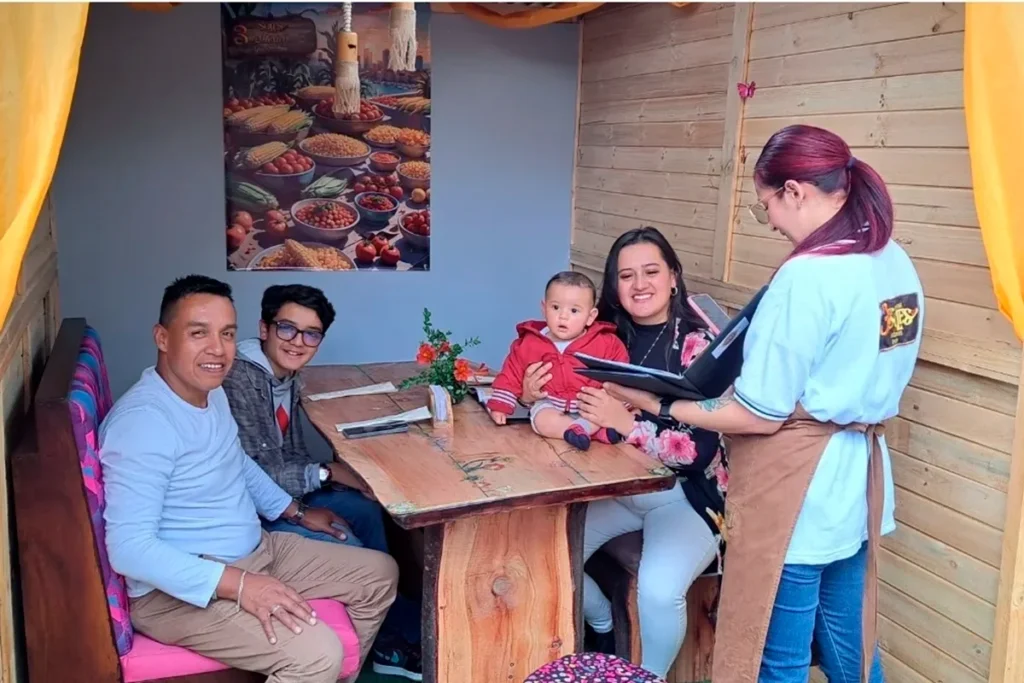 Familia con bebé recibe atención de mesera en cabaña de 3 Soles en Chía
