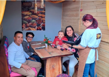 Familia con bebé recibe atención de mesera en cabaña de 3 Soles en Chía