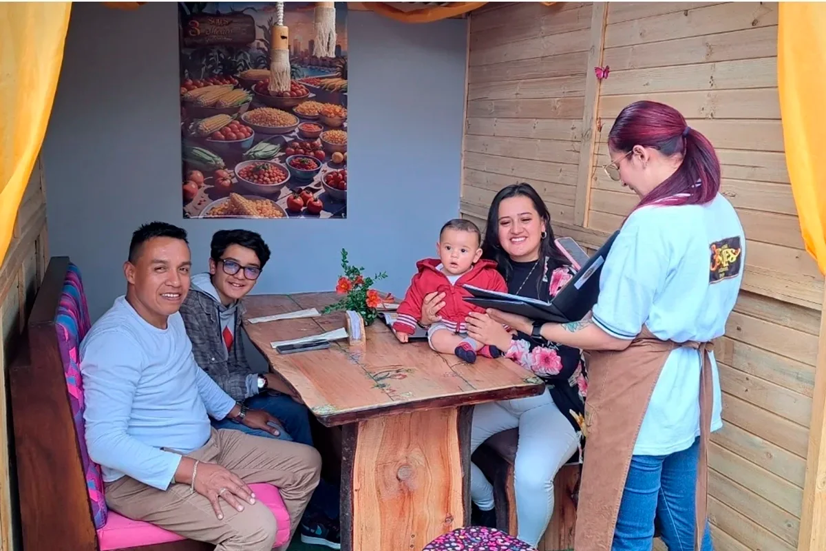 Familia con bebé recibe atención de mesera en cabaña de 3 Soles en Chía