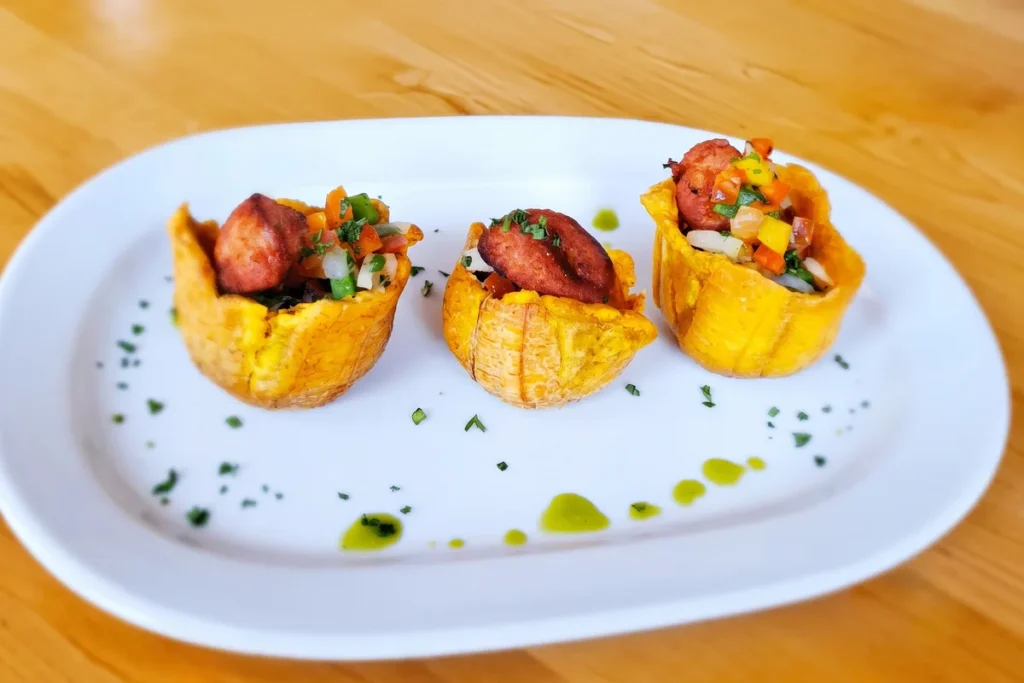 Tres canastillas de plátano rellenas para compartir servidas en plato blanco en restaurante 3 Soles en Chía.