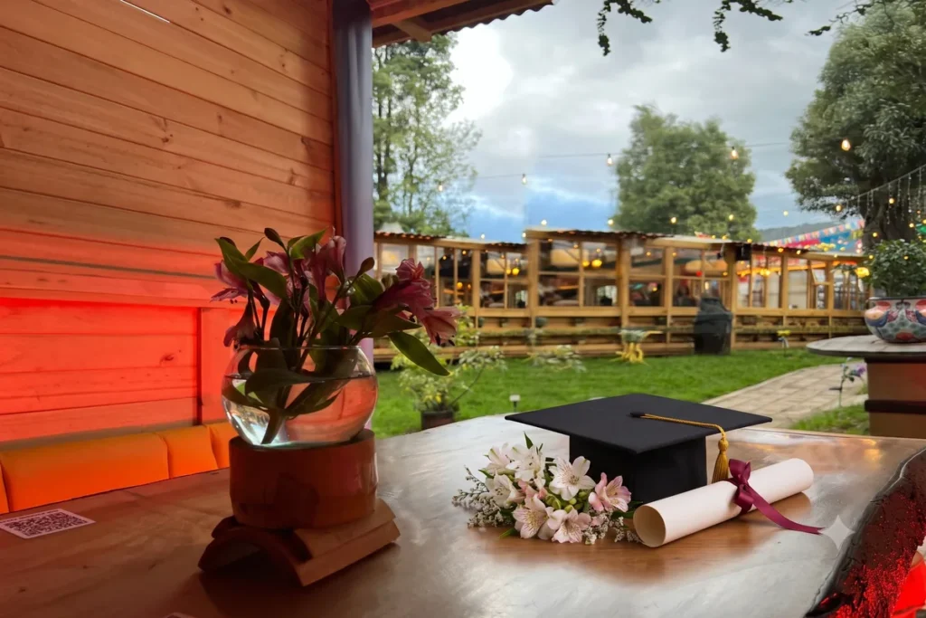 Mesa decorada con birrete, diploma y flores para una celebración de grado en Chía en 3 Soles.