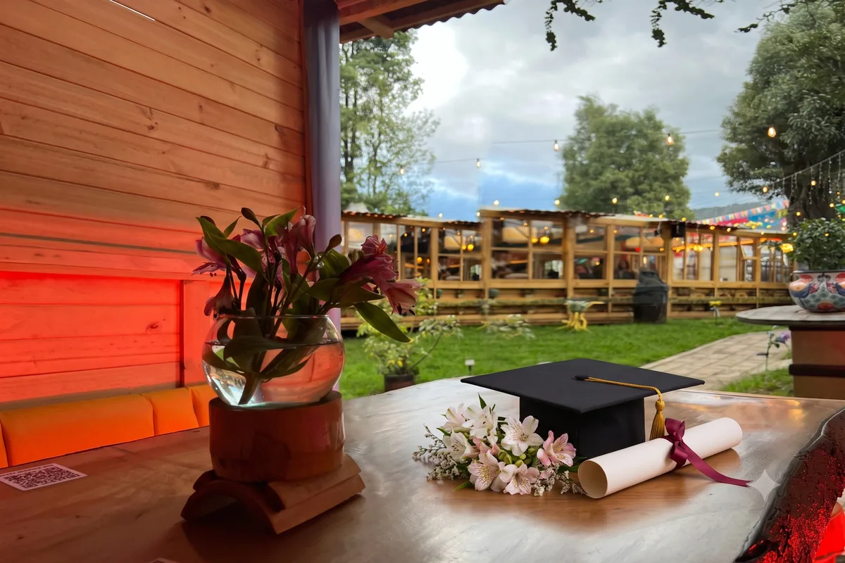 Mesa decorada con birrete, diploma y flores para una celebración de grado en Chía en 3 Soles.