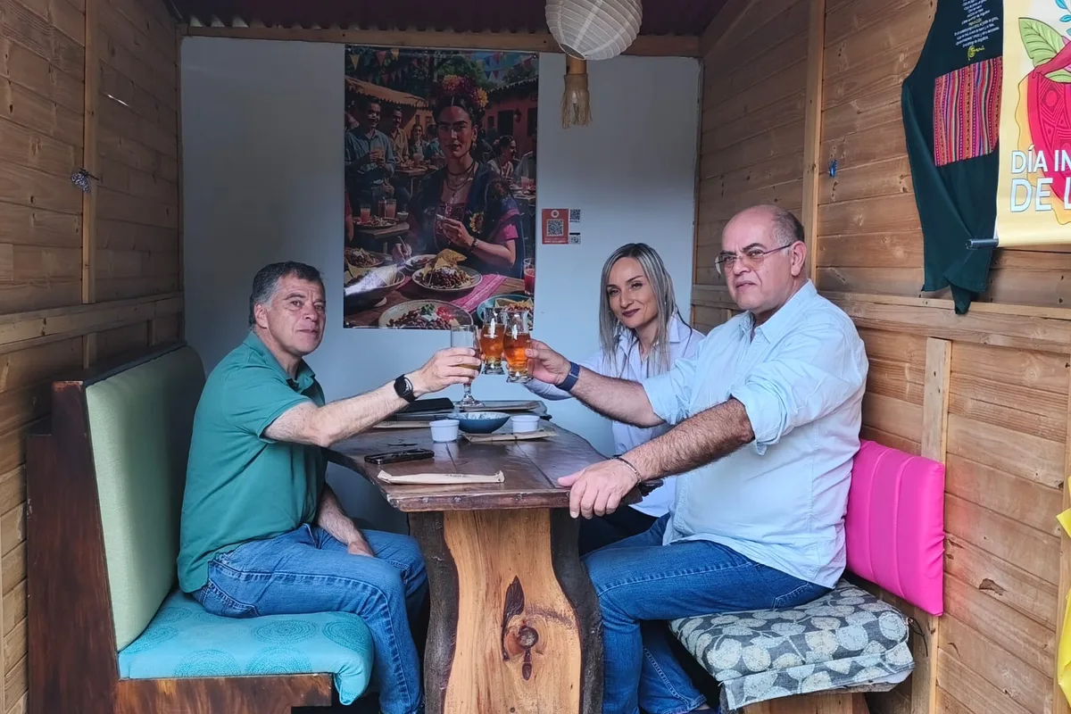Tres personas brindando dentro de un kiosco privado de madera en restaurante 3 Soles en Chía.