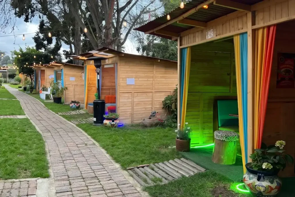 Kioscos privados de madera alineados en las zonas verdes del restaurante 3 Soles en Chía.