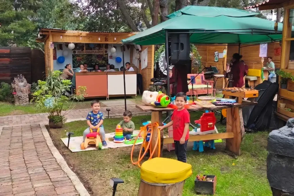 Niños jugando en la zona infantil al aire libre de un restaurante familiar en Chía con menú infantil.