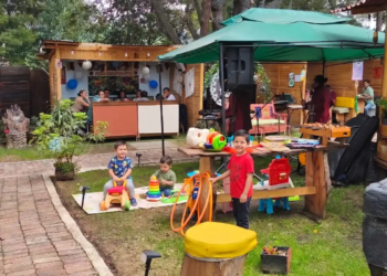 Niños jugando en la zona infantil al aire libre de un restaurante familiar en Chía con menú infantil.