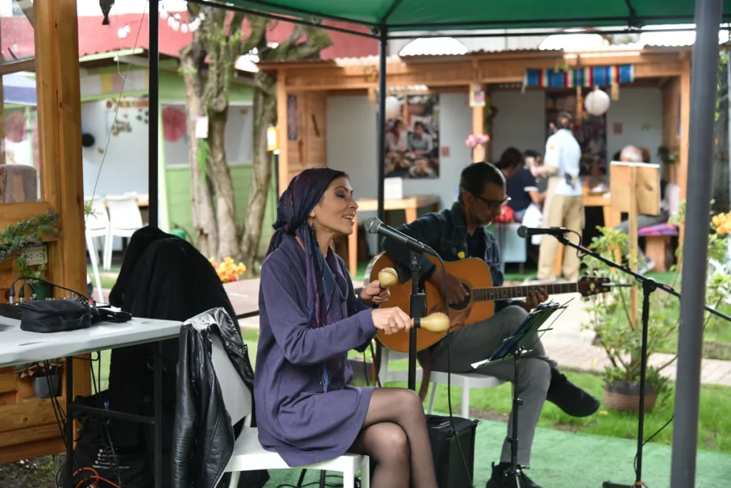 Artistas tocando guitarra y maracas durante un show de música en vivo en Chía en 3 Soles.