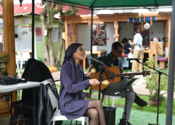 Artistas tocando guitarra y maracas durante un show de música en vivo en Chía en 3 Soles.