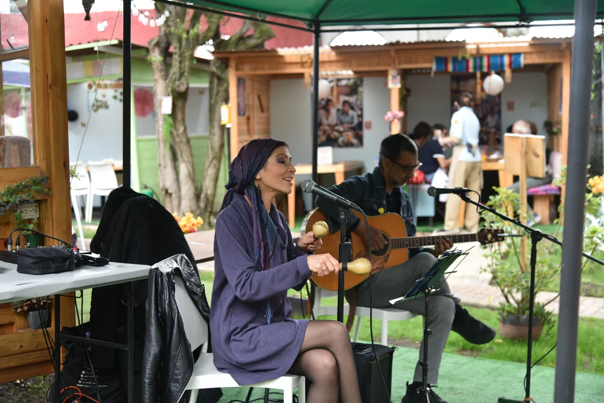 Artistas tocando guitarra y maracas durante un show de música en vivo en Chía en 3 Soles.