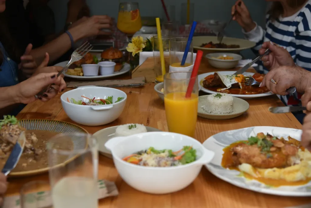 Familia compartiendo diversos platos y jugos en la mesa durante un plan de fin de semana en Chía.