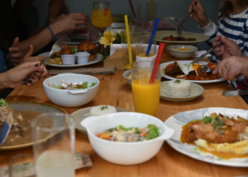 Familia compartiendo diversos platos y jugos en la mesa durante un plan de fin de semana en Chía.