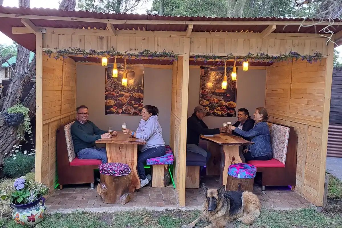 Grupo de personas compartiendo en un quiosco de madera en el restaurante para grupos 3 Soles en Chía.