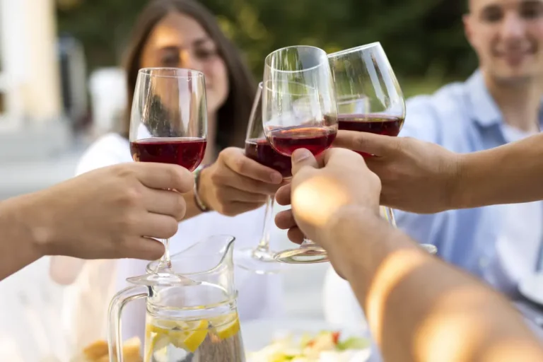 Grupo de amigos brindando con copas de vino tinto durante la celebración de Amor y Amistad en un restaurante en Chía.