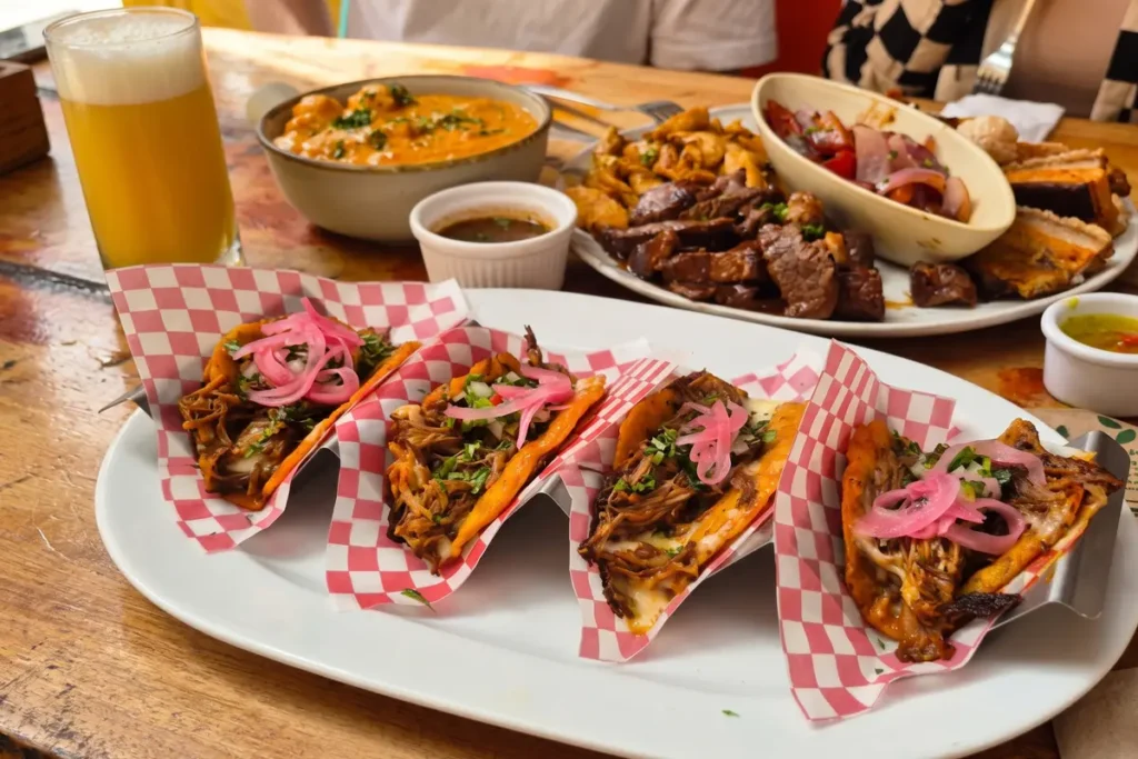 Mesa servida con tacos, carnes y cerveza para compartir en la celebración de Amor y Amistad en Chía.