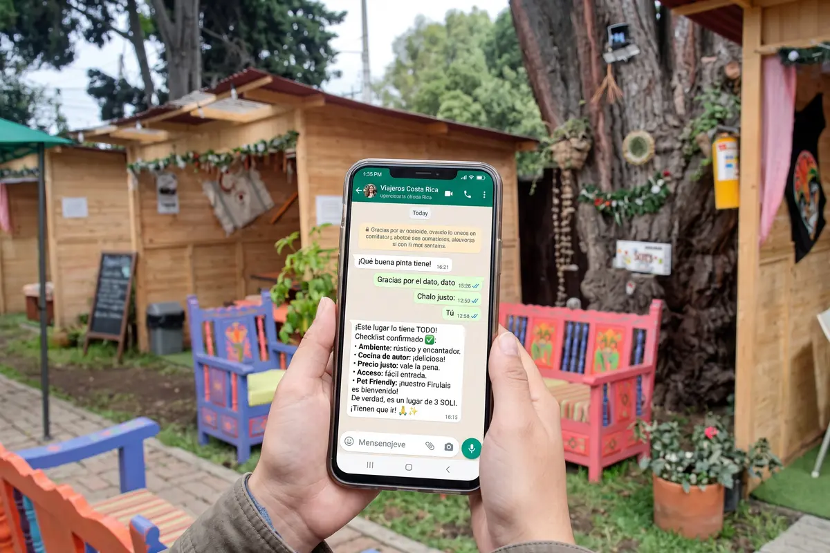 Mano sosteniendo un celular con un chat de recomendaciones para elegir un restaurante campestre cerca de Bogotá.