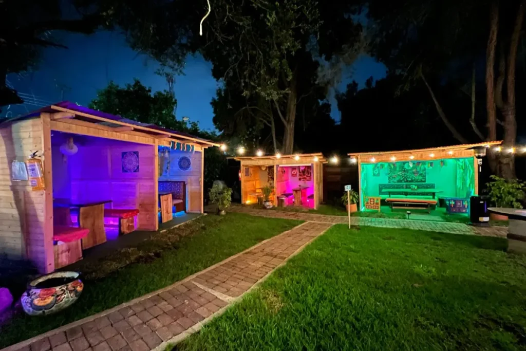 Wooden gazebos with colorful night lighting in the garden of a country restaurant in chia.