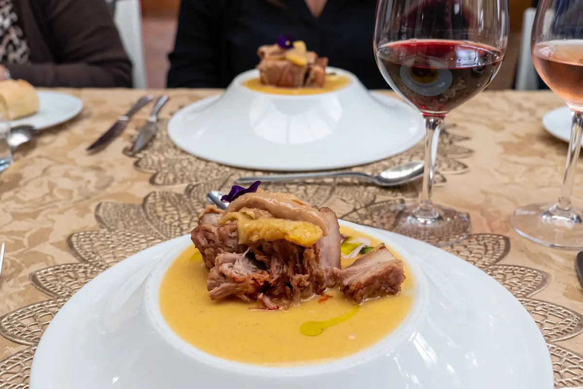 Plato gourmet de cocina fusión servido junto a copas de vino tinto y rosado para maridaje en Chía.