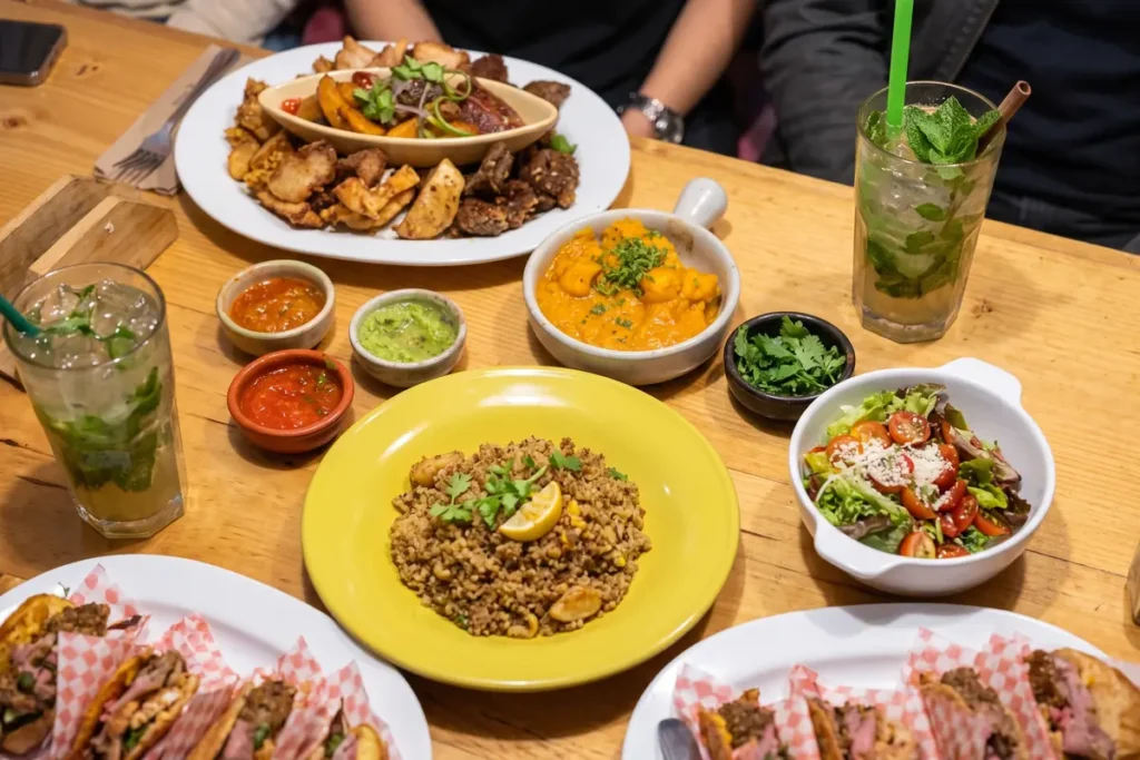 Mesa servida con platos de cocina fusión colombiana, mexicana y peruana junto a cócteles refrescantes en un restaurante de Chía.