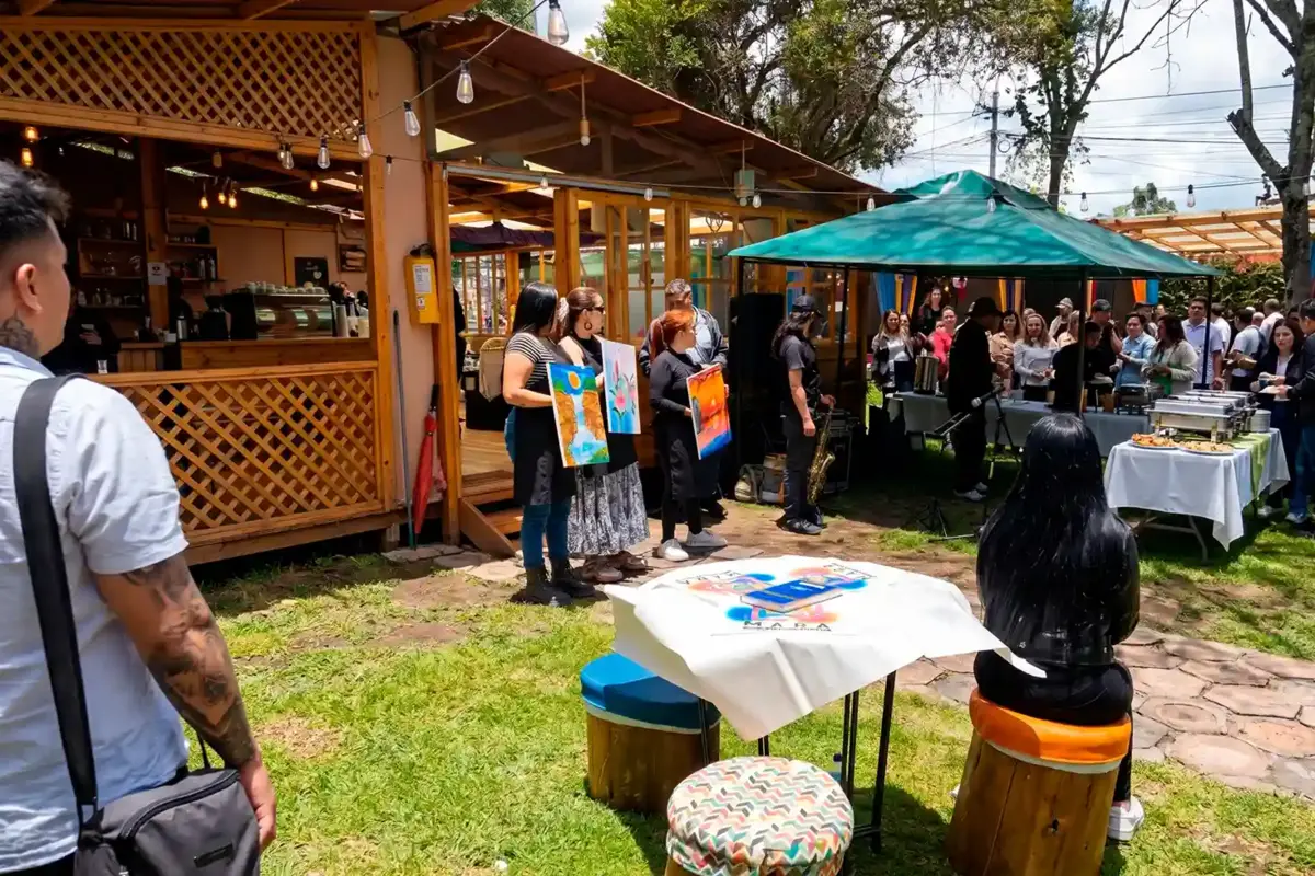 People enjoying an outdoor event with an art painting display and buffet setup during october plans in chia.