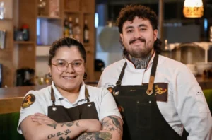 Pareja de chefs sonriendo en su restaurante 3 Soles tras recibir en Chía.