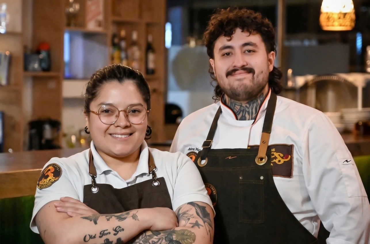 Pareja de chefs sonriendo en su restaurante 3 Soles tras recibir en Chía.