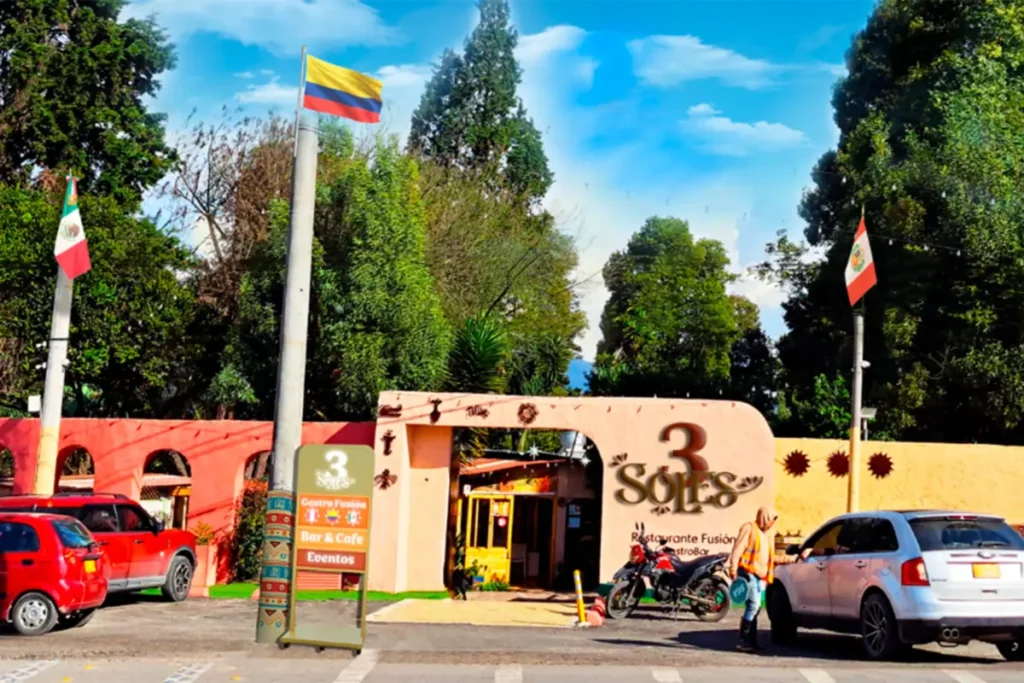 Main entrance of 3 soles restaurant displaying flags of colombia, mexico, and peru representing its culinary fusion.